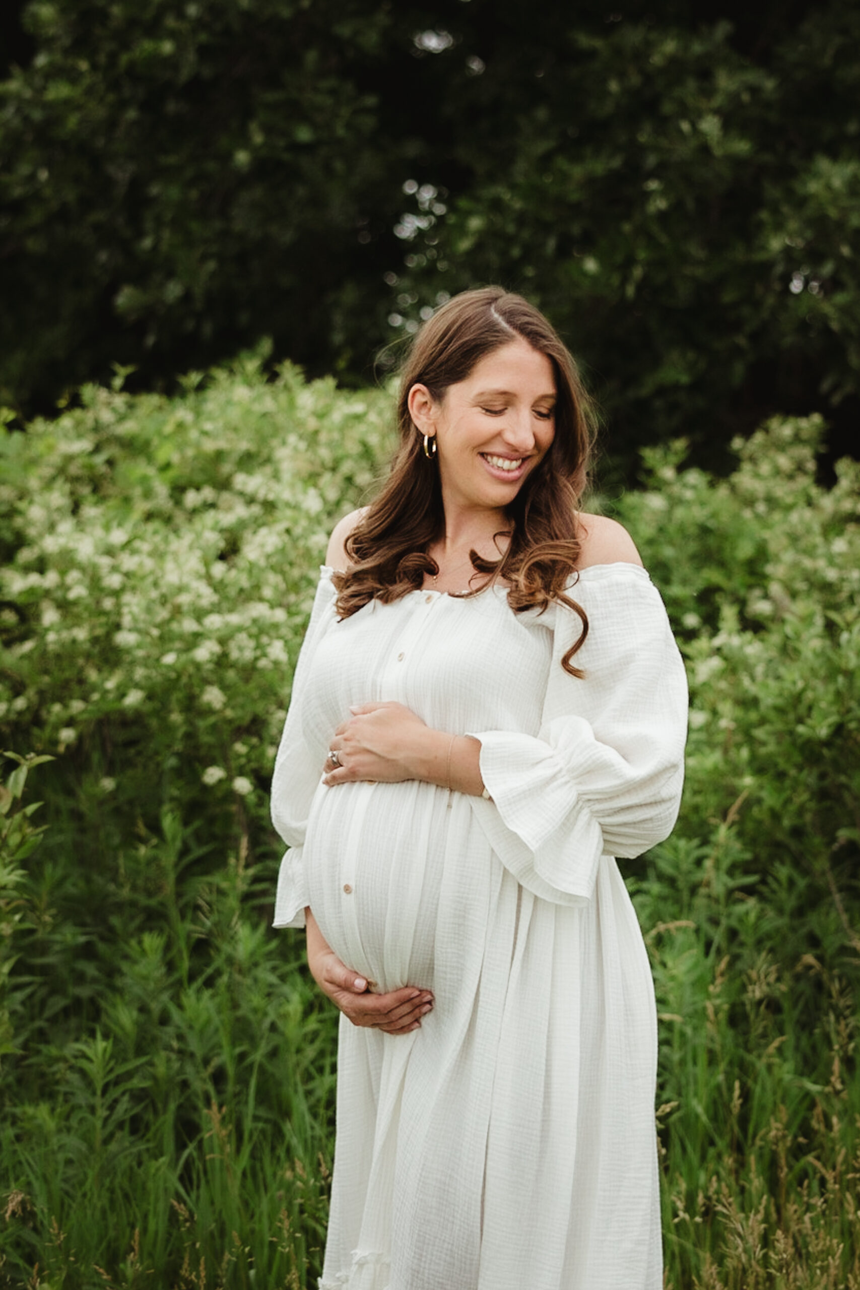 A pregnant mom cradles her growing belly during her maternity photos session.