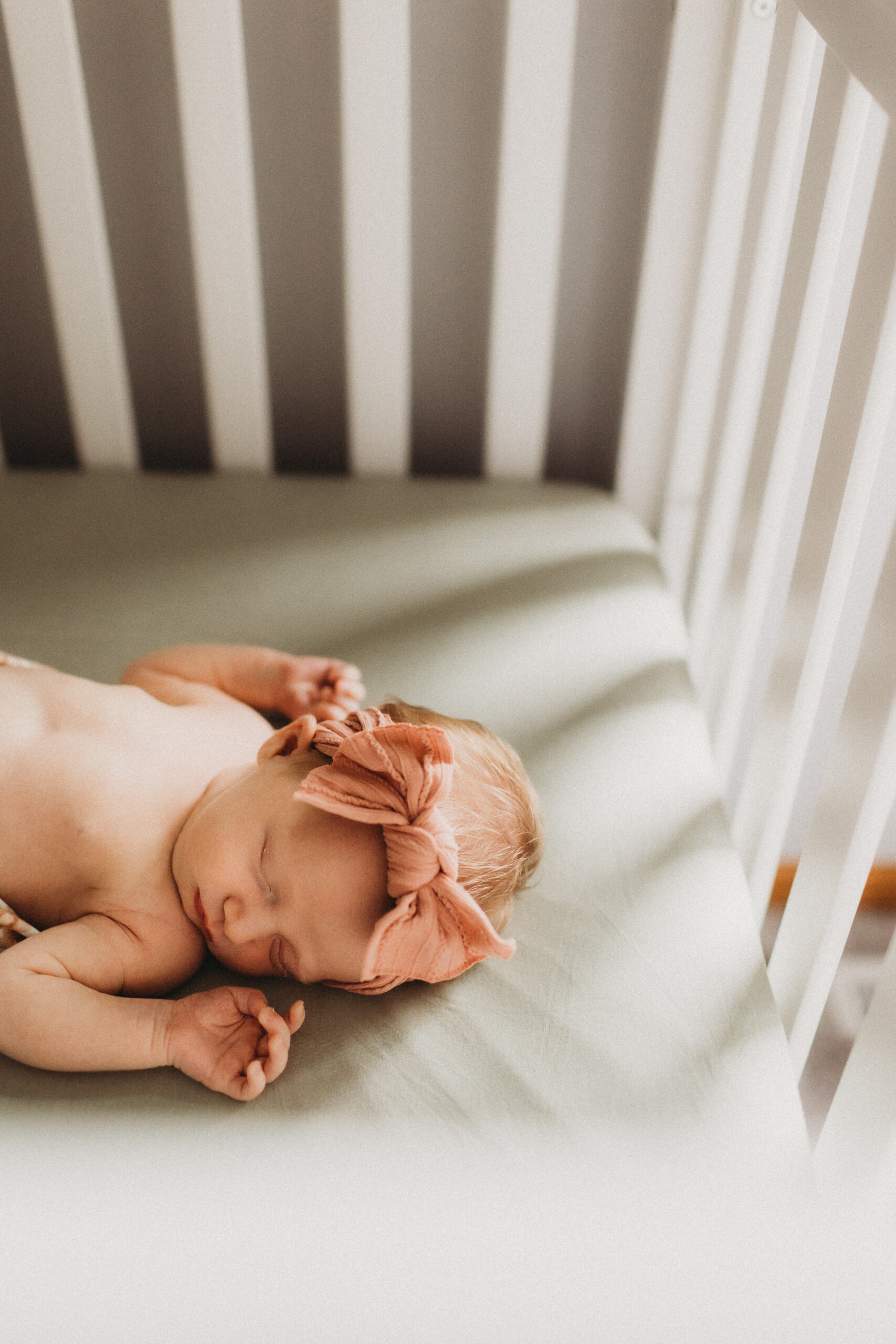 A newborn baby sleeps peacefully in her crib.