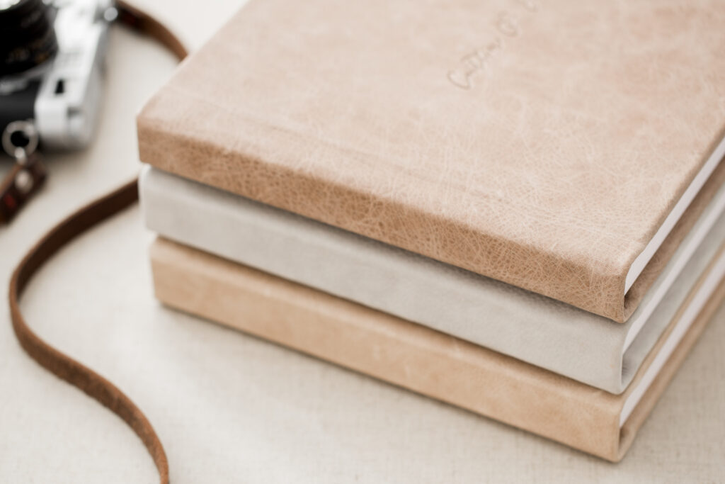 A photo of three beautiful leather albums stacked on top of each other as we explore the importance of printed photos.