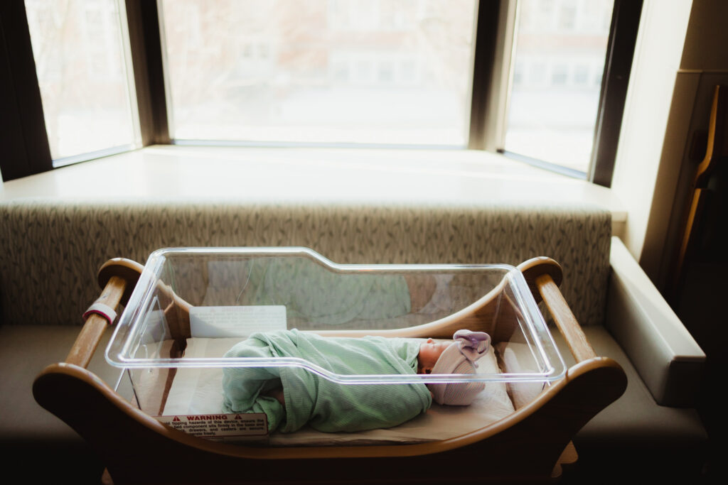 A newborn baby sleeping in their bassinet after her Madison hospital birth.