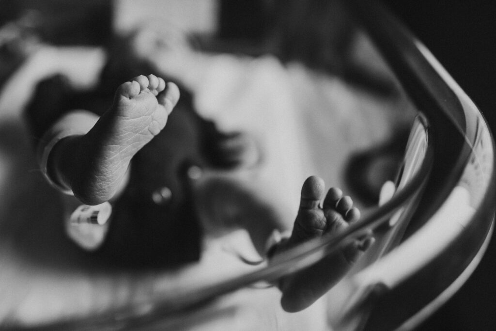 Newborn baby peacefully resting in a hospital room, showcasing the caring environment where Madison midwives support families during their childbirth journey.