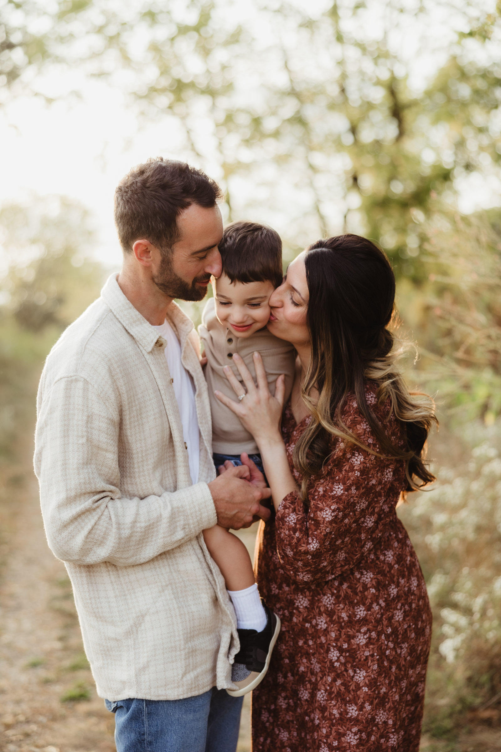 A family of three laughs and snuggles together during their family photography session by Sun Prairie Photographer, Elizabeth Pachniak Photography.