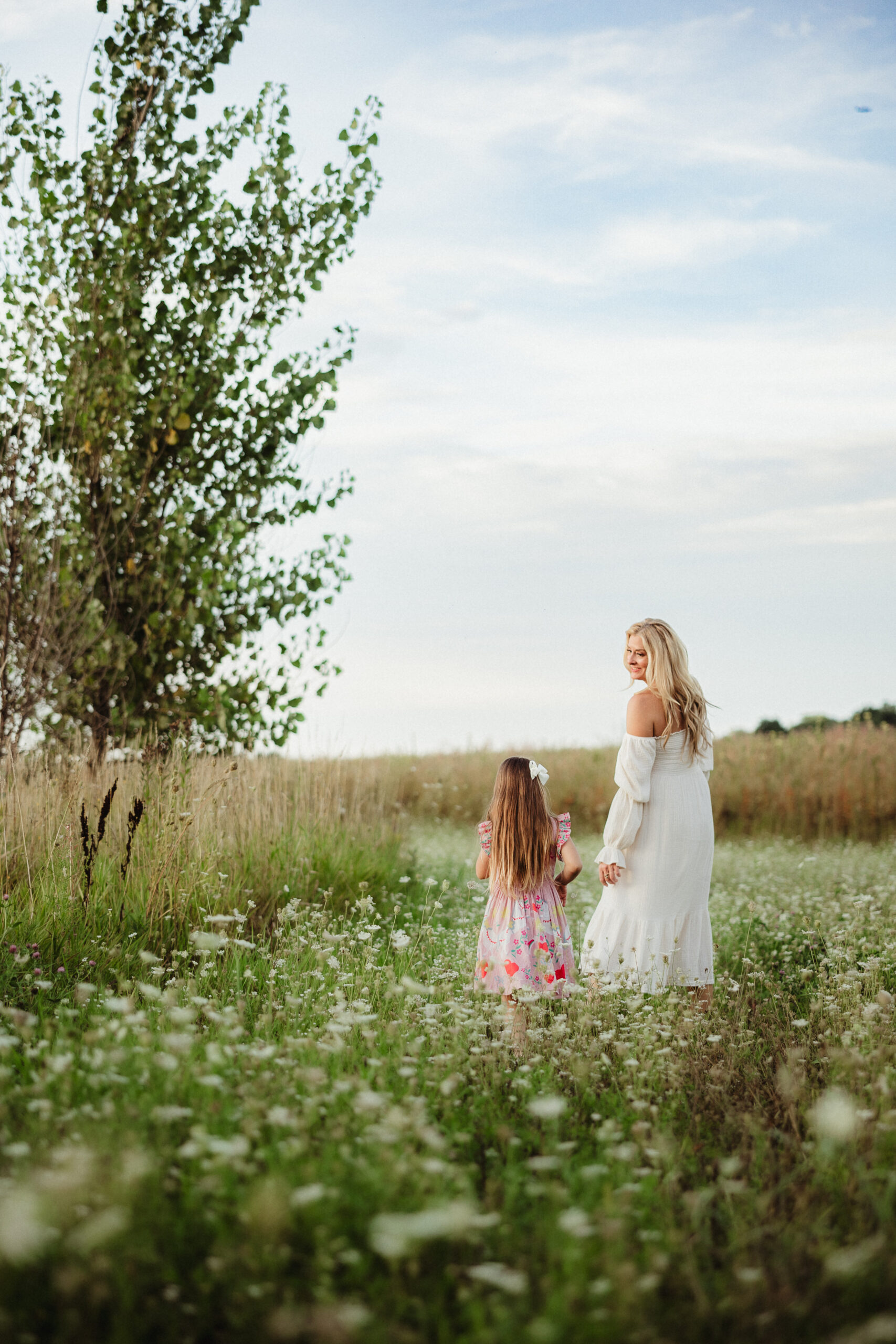 A mother and daughter play in a field of wildflowers together during their mommy-and-me photography session in Madison, WI.